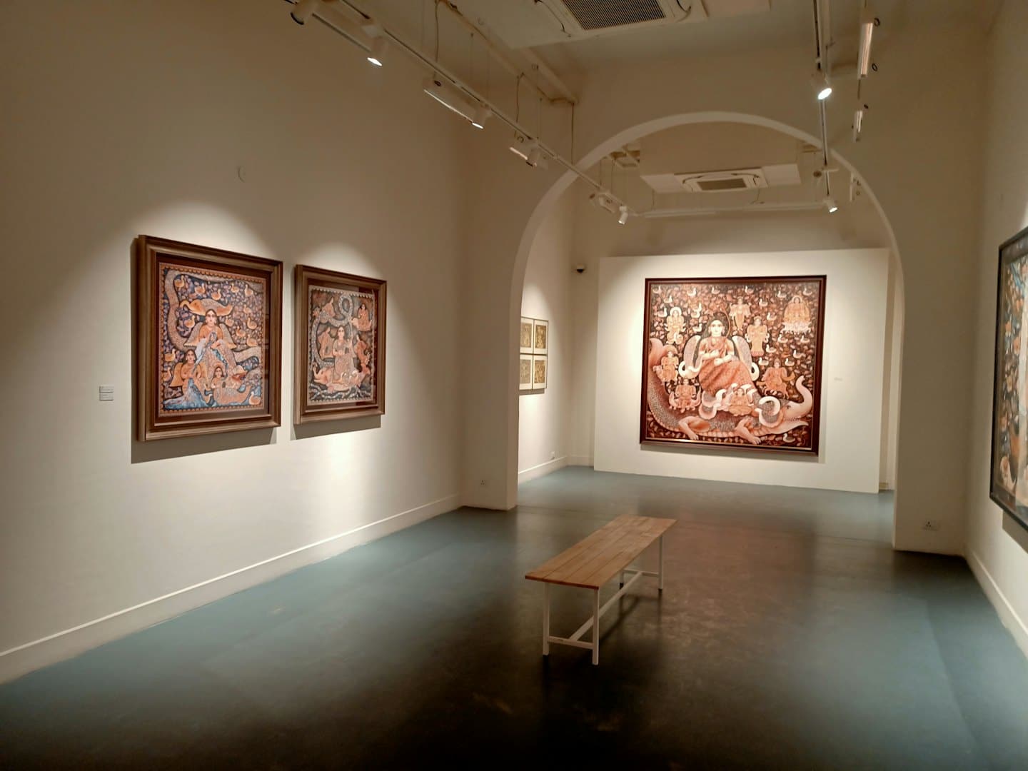 Eine Holzbank steht in einer modernen weißen Kunstgalerie.